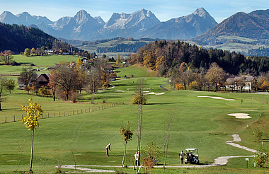zeigt den Golfplatz mit den Blick auf die Berge