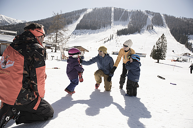 zeigt Kinder und Eltern im Skikinderland