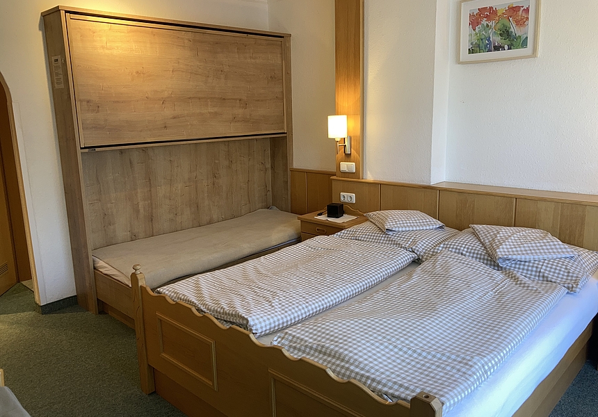 zeigt das Doppelbett und Stockbett vom Kinderzimmer
