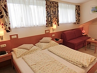Blick auf das Doppelbett und die Couch vom Kinderzimmer Enzian